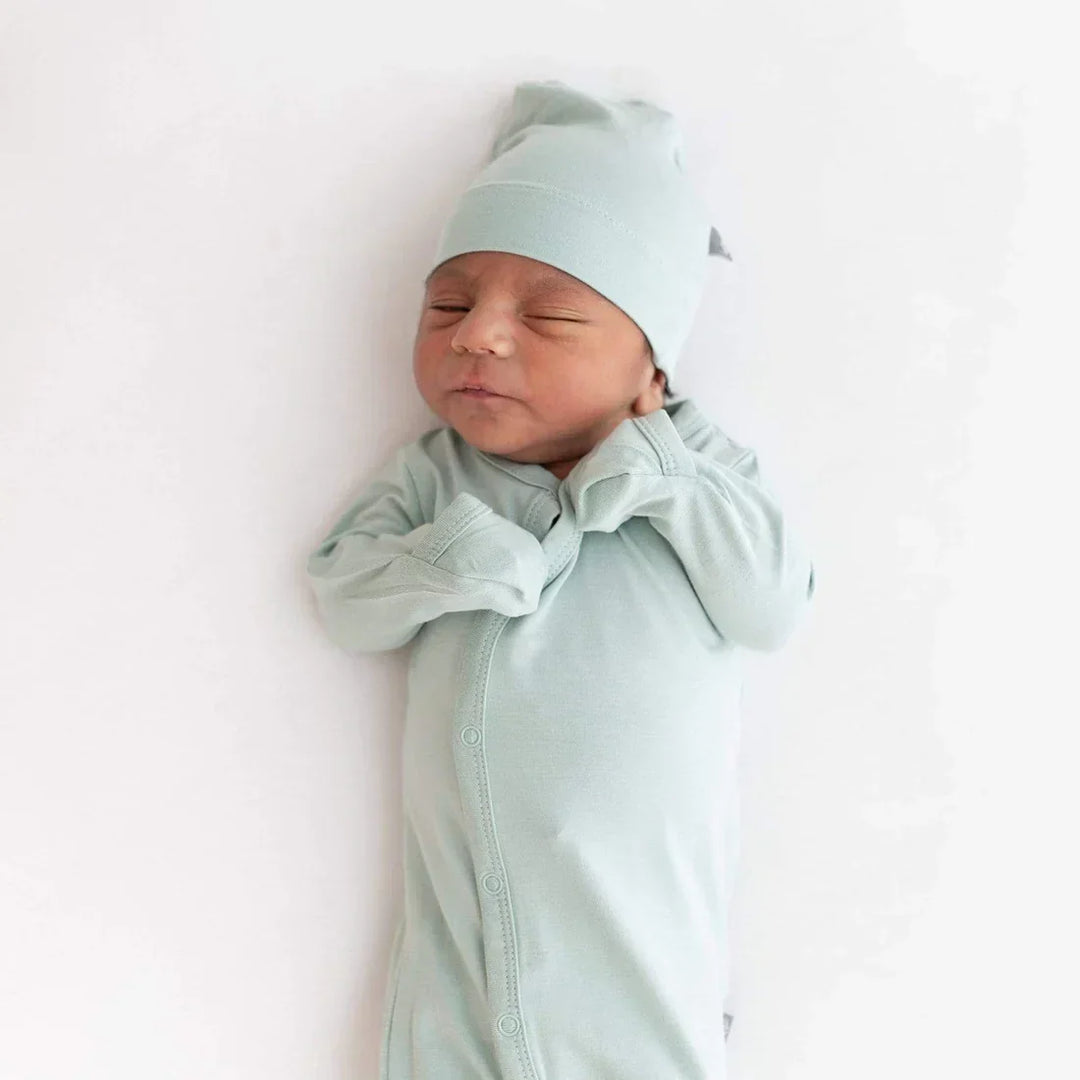 newborn baby searing his hat and romper, part of the layette checklist.