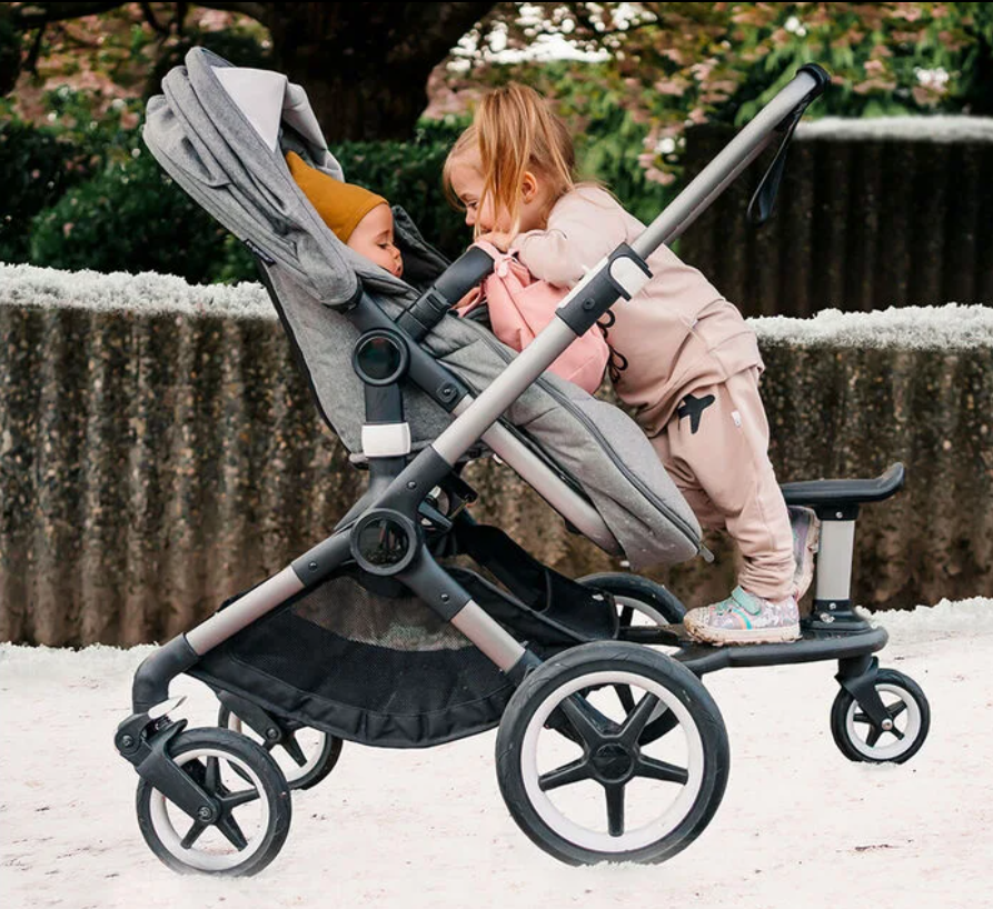 child on wheelboard and in seat of bugaboo fox stroller