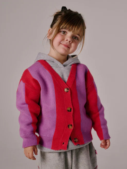 Children’s cardigan with bold pink & purple stripes, button-up front, and relaxed fit, laid flat to show knit texture and design