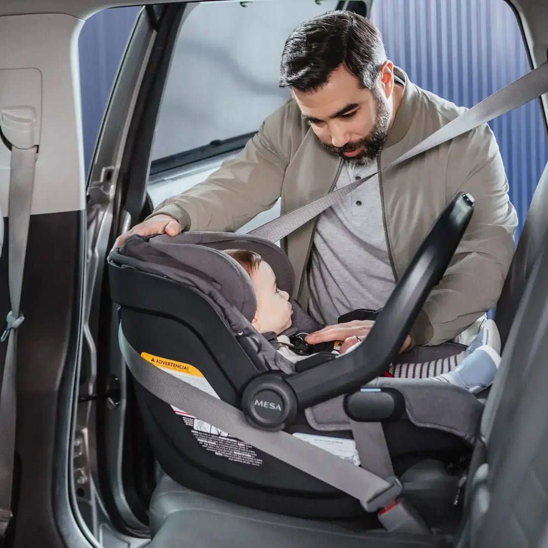 father installing mesa 3 by uppababy using seatbelt