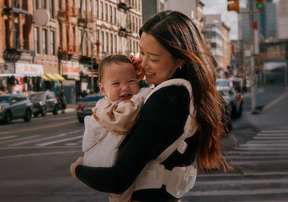 beautiful woman carrying her child in the city