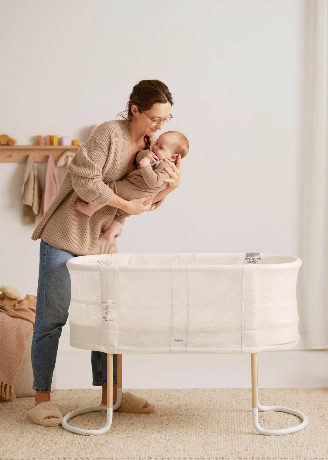 Woman putting baby to be in baby bjorn cradle