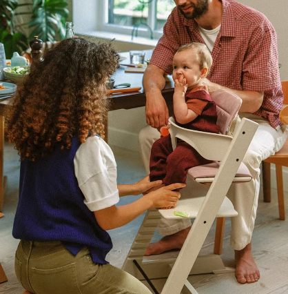 baby and parents with stokke tripp trapp high chair