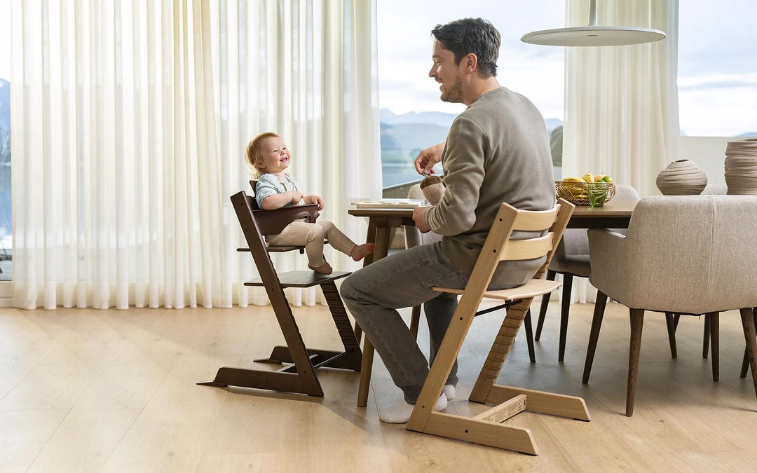 Man sitting with baby in tripp trapp chair