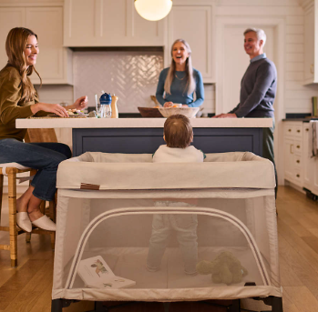 family in kitchen with baby in remi travel crib