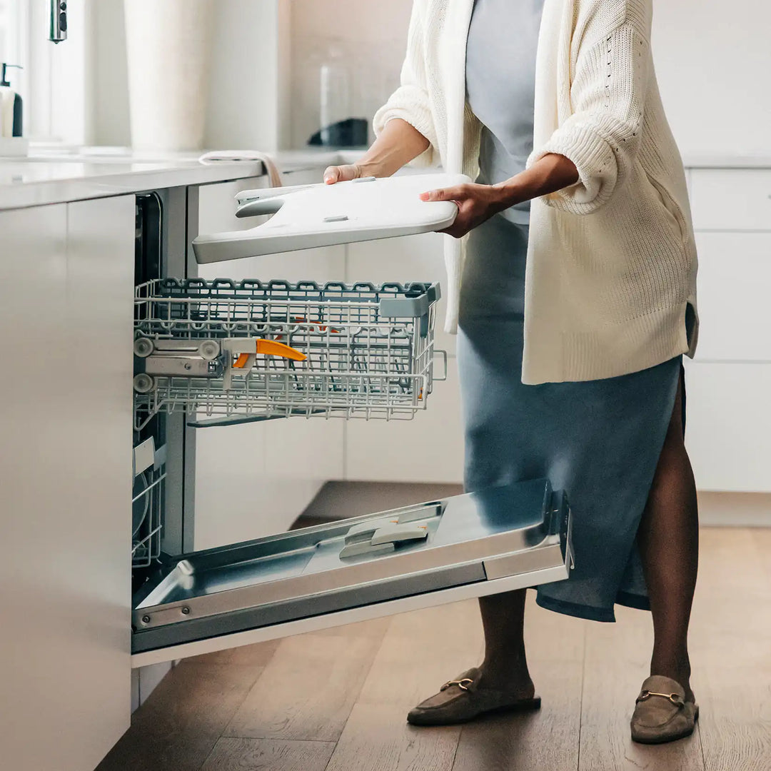 Person opening a dishwasher in a kitchen