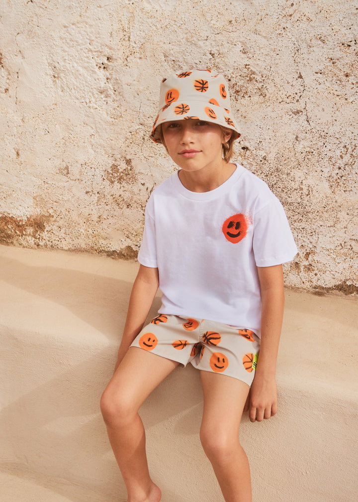 Boy wearing Niks Fun Play Hat by Molo featuring basketball print