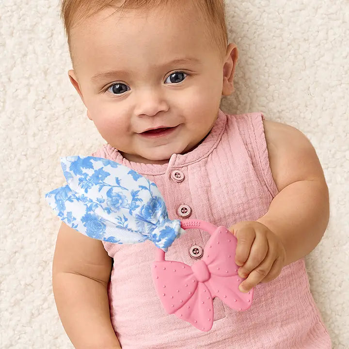 baby holding crinkle crew pink bow by itzy ritzy