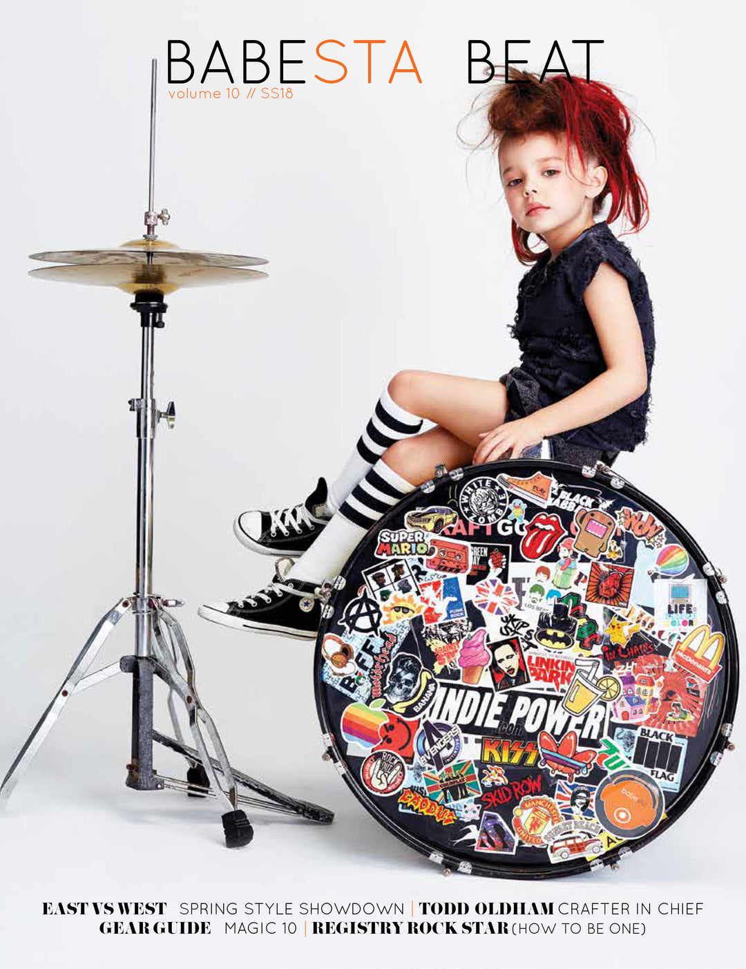 Magazine cover with a child sitting on a drum with stickers, featuring the brand 'Babesta Beat'.