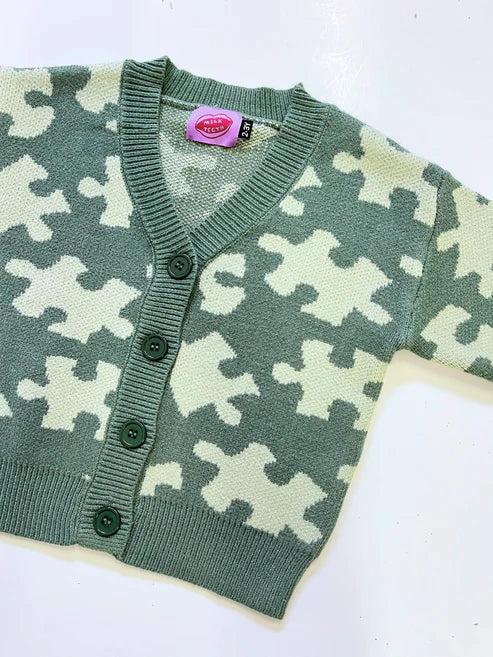 Milk Teeth Green Puzzle Sweater featuring playful geometric knit pattern in soft cotton, laid flat on a neutral background