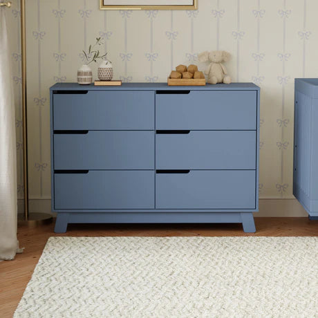 Blue dresser with decorative items in a nursery setting