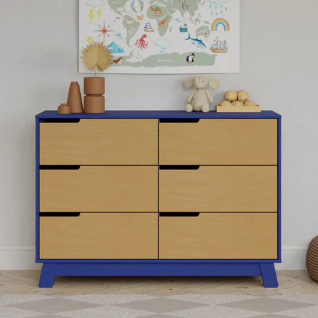 Wooden dresser with blue frame and beige drawers in a room with toys and a world map on the wall.