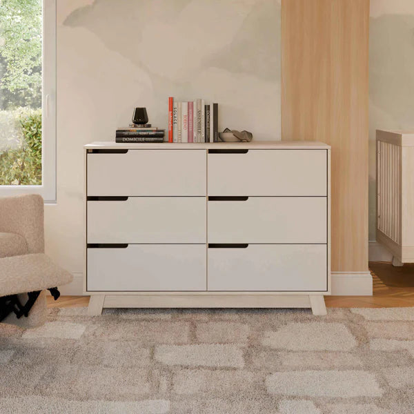 White dresser with 6 drawers in a room with a window and radiator.