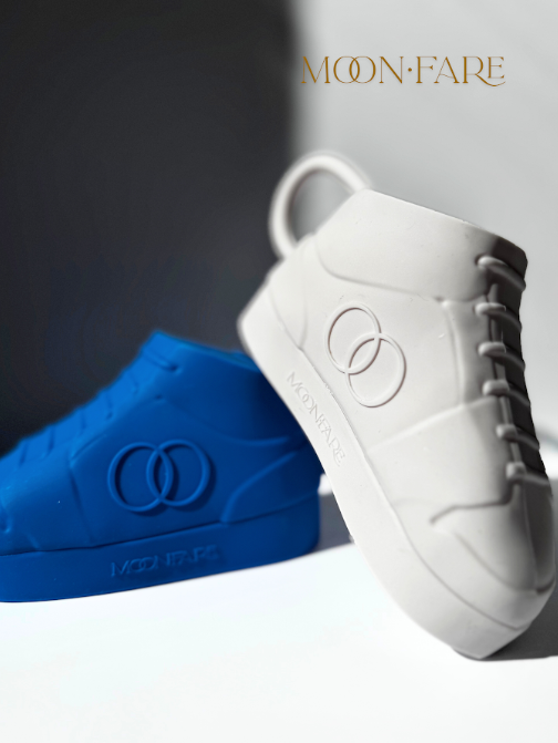 White and blue sneakers with 'MOON-FARE' branding on a gray background